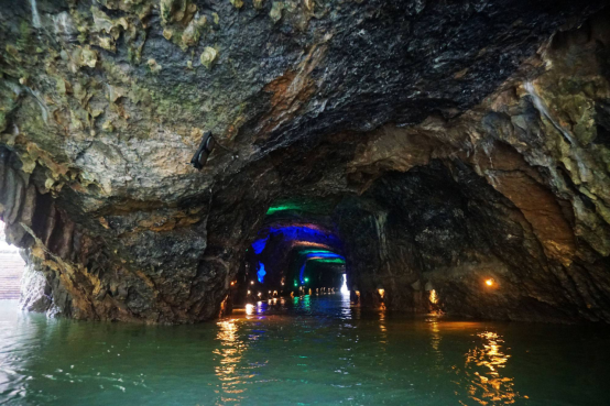 Boat traveling beneath a natural opening at Jiudongtian