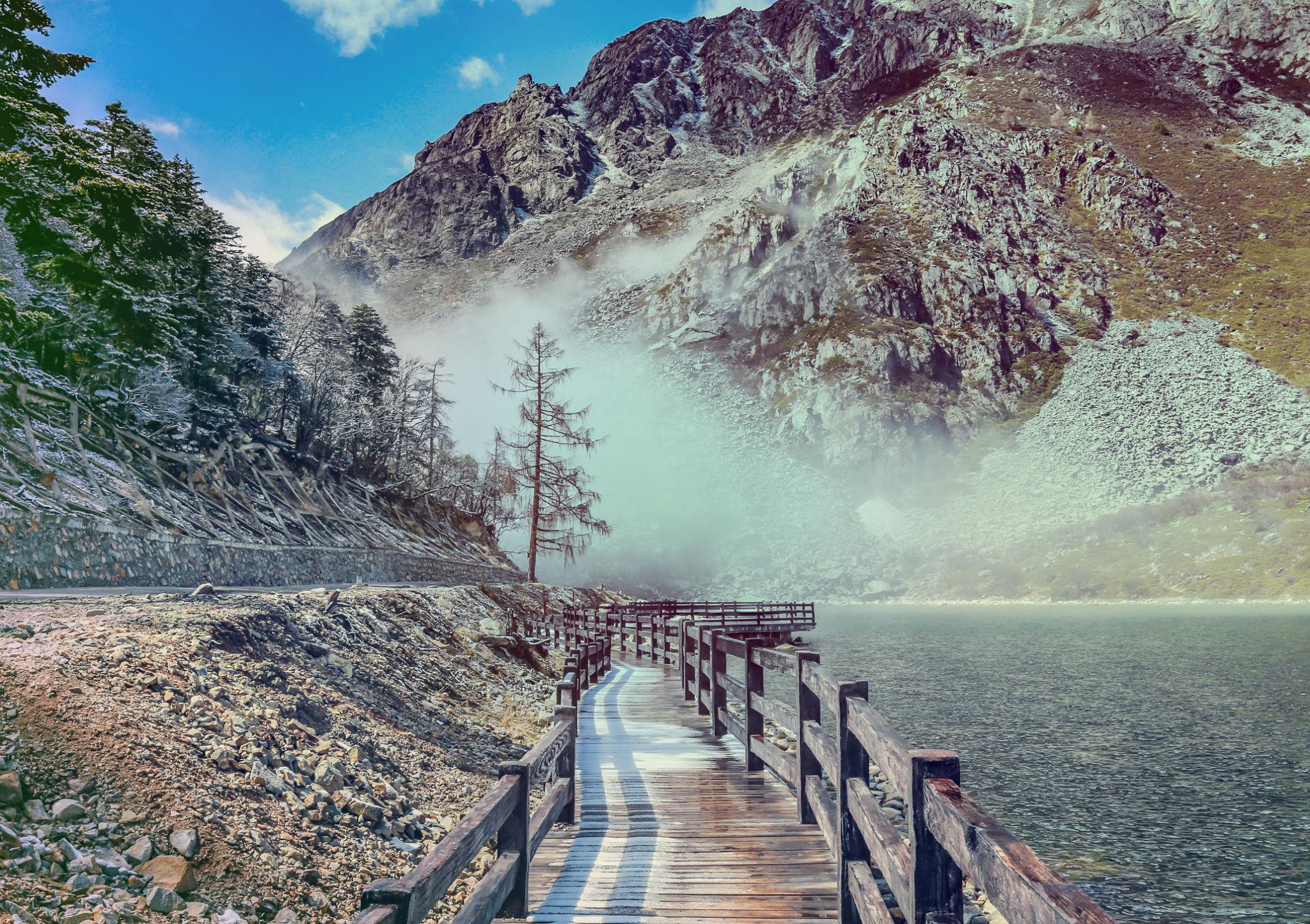 WOODEN BRIDGE NEAR smooth water of Mugecuo Lakes China landscape